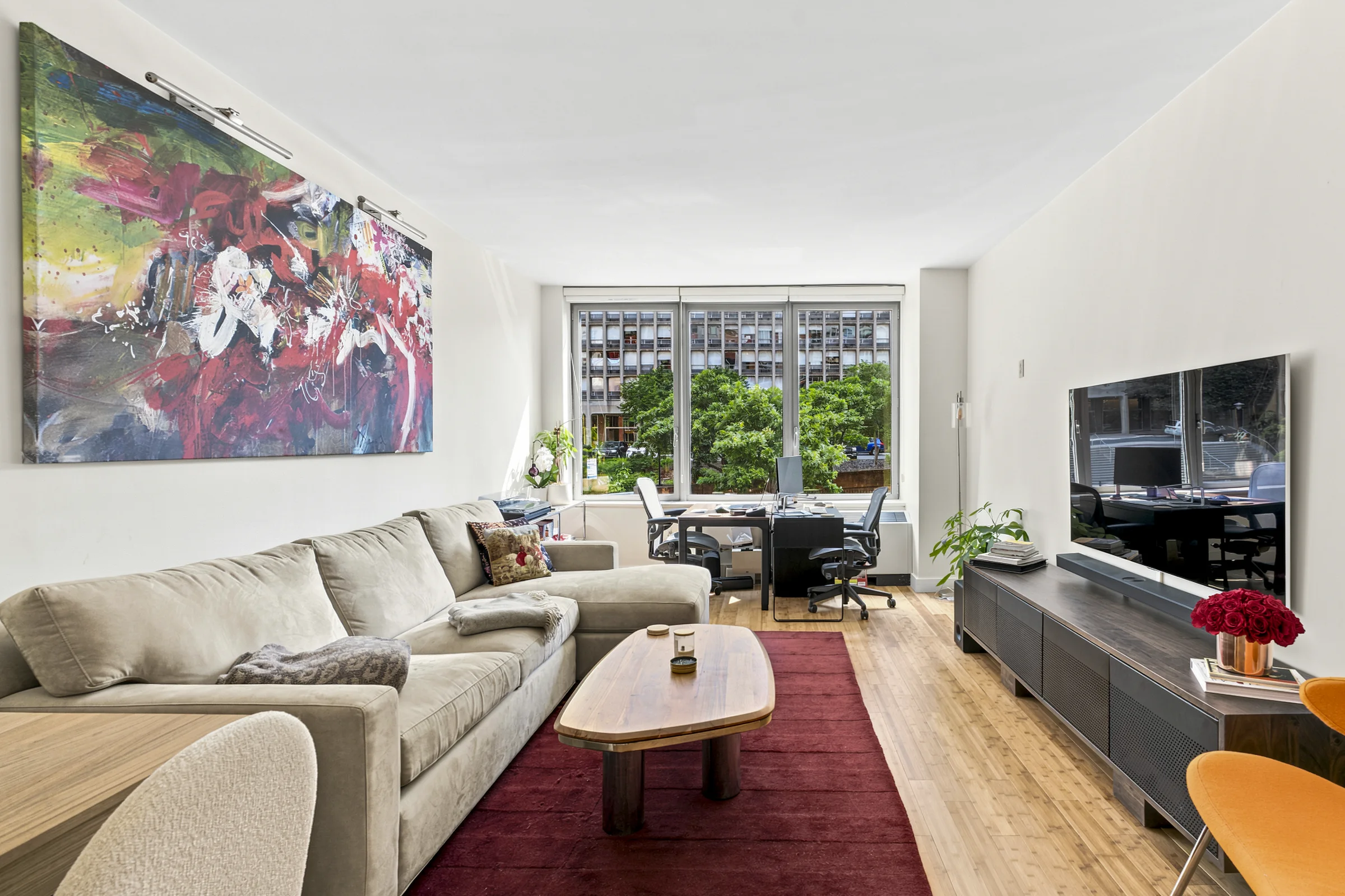 Bright living room with colorful artwork and large windows